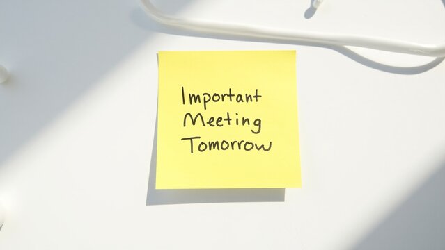 Handwritten yellow post-it note with the reminder to have an important meeting today.