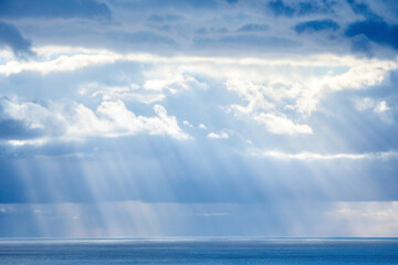 Dramatic ocean landscape with sunbeams piercing through clouds © PixelCraft Studio