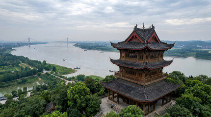 Fototapeta premium Aerial view of the ancient wooden pavilion overlooking the yangtze river and a suspension bridge in china