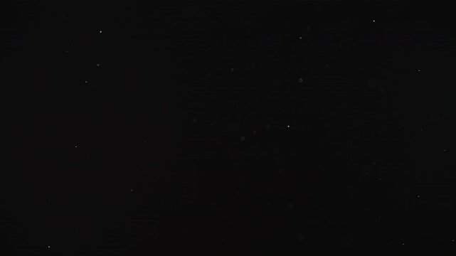 Slow motion real dust particles floating mid air over dark background