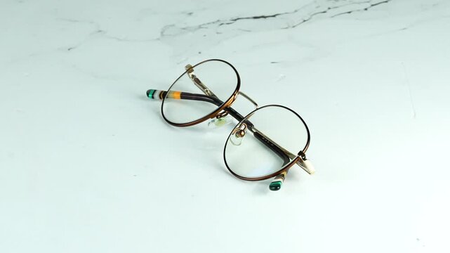 Luxury round gold glasses with dioptre rotating 360 degrees on a white background Premium optical frames 4K video