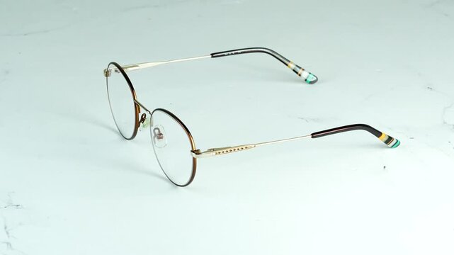 Luxury round gold glasses with dioptre rotating 360 degrees on a white background Premium optical frames 4K video