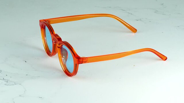 Modern orange transparent glasses rotating 360 degrees on a white background Stylish fashion optical frames Video