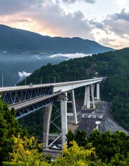 Obraz premium A serene mountain landscape with a long elevated bridge