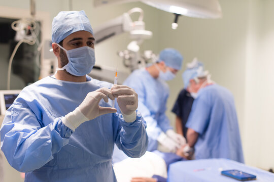 Surgeon preparing syringe before eye surgery in a modern Middle Eastern hospital operating room in Egypt