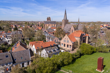 Obraz premium Aerial view of the historic core of Wijk bij Duurstede with Gothic Grote Kerk tower and Sint-Johannes spire above red-tiled roofs, Netherlands