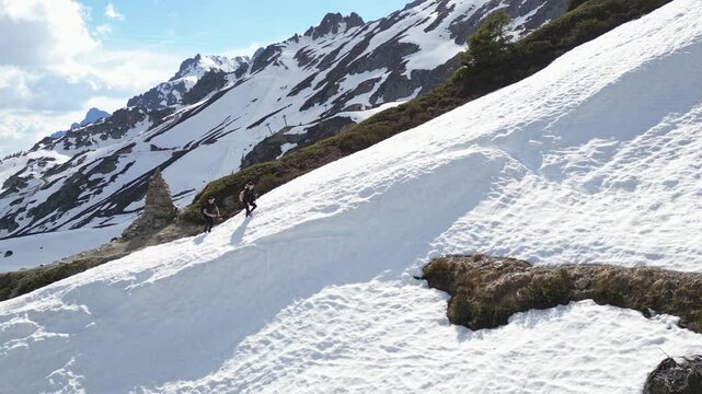 Snow hikers crossing a scenic alpine trail near Lac Blanc in Chamonix, France, surrounded by snowy peaks and dramatic mountain landscapes in the French Alps.