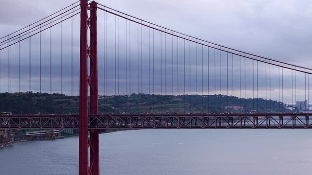 Traffic on Ponte 25 de Abril suspension bridge at sunset on Tagus River estuary, Lisbon, Drone shot