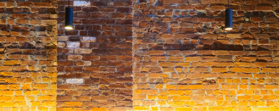 Cozy restaurant dining room with warm lighting, brick wall decor, wooden tables and pendant lights.