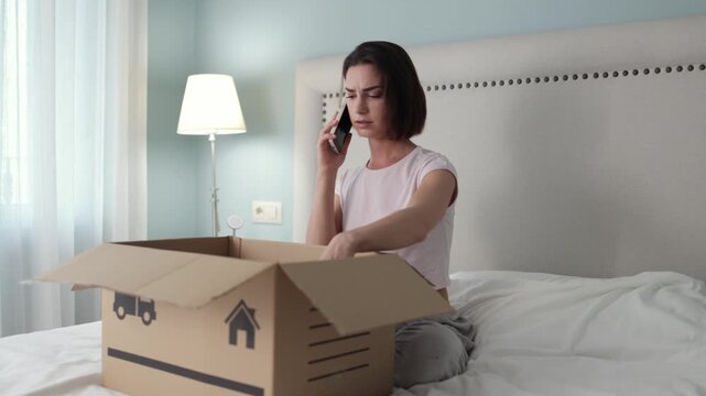 Angry woman on phone beside delivery package expressing dissatisfaction. Concept ecommerce support and consumer rights.
