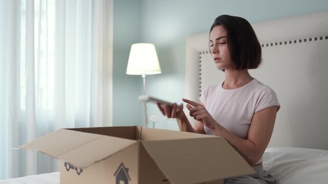 Woman upset while calling courier service next to unboxed product. Concept online retail complaint and service quality.
