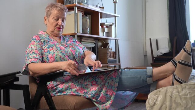Elderly senior woman playing a card game of solitaire.