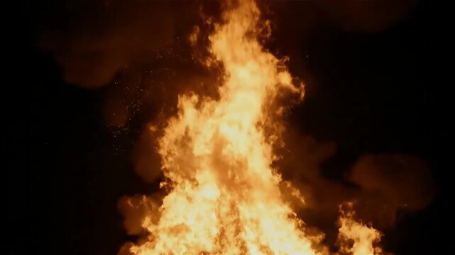 Intense bonfire blaze at night, capturing the raw power and vibrant dance of flames against the dark sky