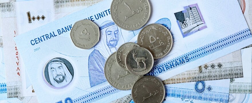 UAE dirham money bills and coins on table. United Arab Emirates cash of AED currency close up