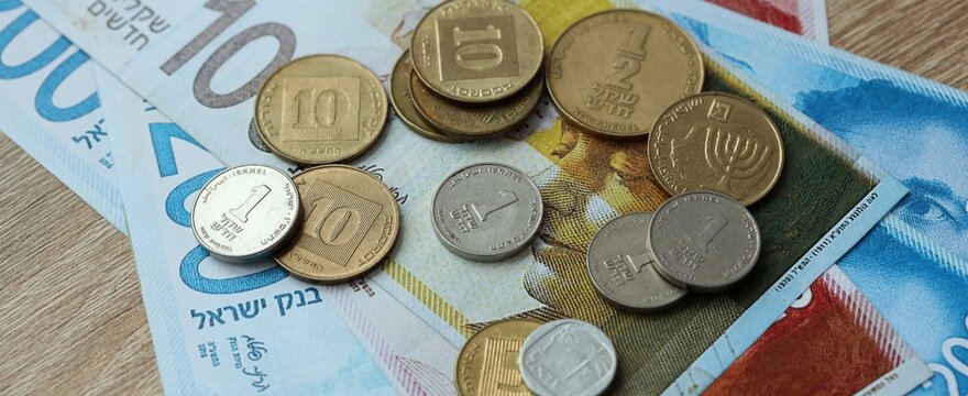 Israeli shekel money bills and coins on table. Israel cash of ILS currency close up