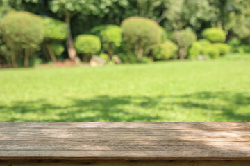 Fototapeta premium Empty wood table top with abstract blur park garden background