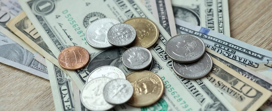 US dollar money bills and coins on table. United States cash of USD currency close up