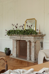 Obraz premium Elegant Room Decor: Gold Mirror, Greenery, and Dark Calla Lilies Adorn a Classic Marble Fireplace in a Bright Interior