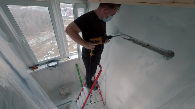 Timelapse of worker drilling wall during air conditioner installation