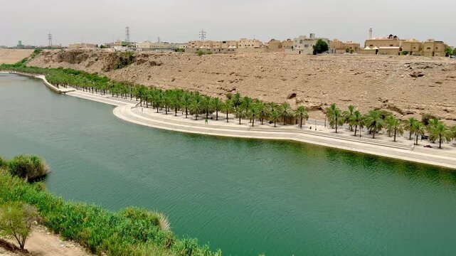 High angle panoramic view of Wadi Hanifa in Riyadh with palm trees and water canal.