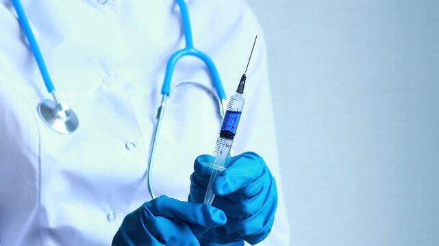 Healthcare worker holds a syringe with a blue liquid in a medical setting during a consultation about vaccinations.