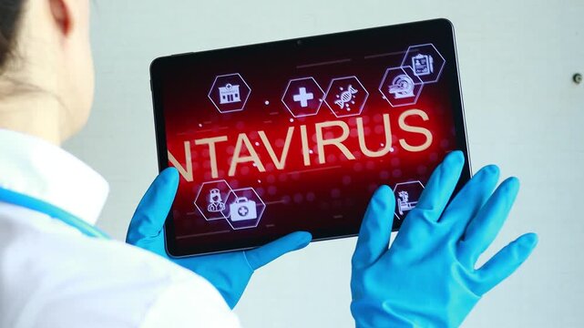 Health worker looks at tablet screen showing information about hantavirus in a medical setting.
