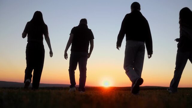Ground level view of five teens walking toward the setting sun