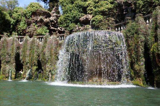 Splendida veduta della storica Fontana dell'Ovato con i suoi iconici giochi d'acqua a cascata e la lussureggiante vegetazione nei giardini rinascimentali di Villa d'Este a Tivoli, Italia.