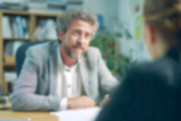 Fototapeta premium Blurred Man in Suit Meeting, Discussing Ideas in Modern Office
