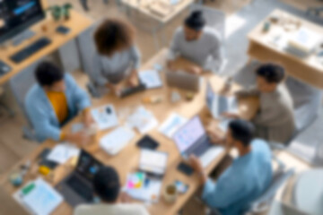 Obraz premium Blurred Diverse team collaborating on business project in modern office space