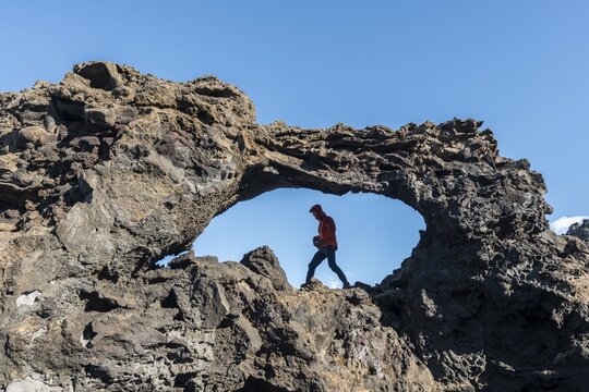 Man in a rock arch, volcanic landscape, Krafla volcanic area, Dimmuborgir National Park, M&yacute;vatn, Iceland