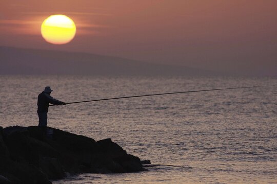 Angler in the backlight at dawn, Larnaca, Cyprus