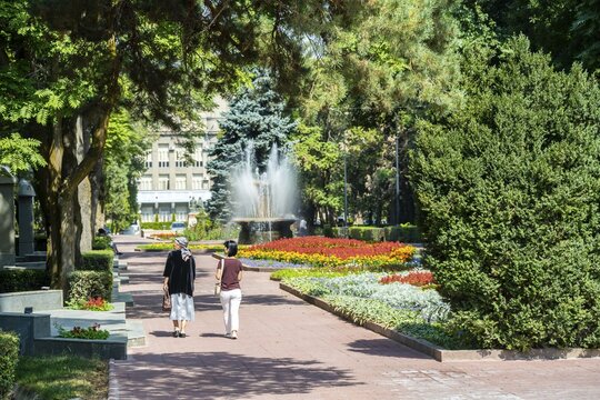 Strollers, flower bed in Panfilov Park, municipal park in Bishkek, Kyrgyzstan