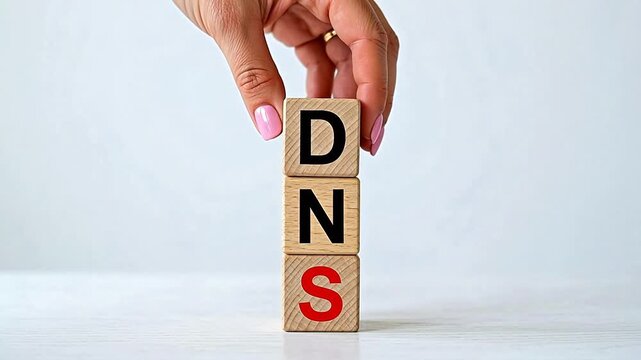 Hand stacking wooden blocks with DNS letters emphasizing fluid motion and vibrant color palettes