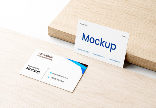 Two Business Card Mockups on Wooden Surface in Minimalist Interior Setting