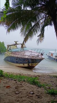 Old Abandoned Yacht on Tropical Beach Shore During Heavy Rain