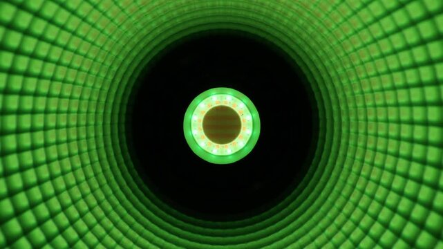 Abstract macro detail of a modern blue LED studio light emitting a bright central glow. The deep concentric circles inside this highly textured reflector create a mesmerizing optical illusion.