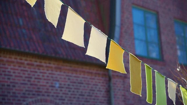 Pastel bunting flags hanging outside brick building for festive event