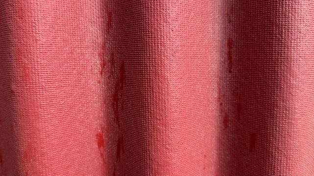 Closeup red corrugated roof texture showing sunlit waves, subtle paint stains, fabric like grain and shadowed ridges, roofer