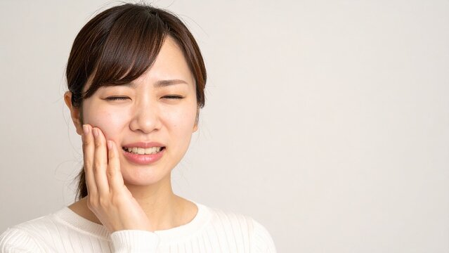 頬を押さえて歯痛に悩む若い日本人女性 AI生成素材