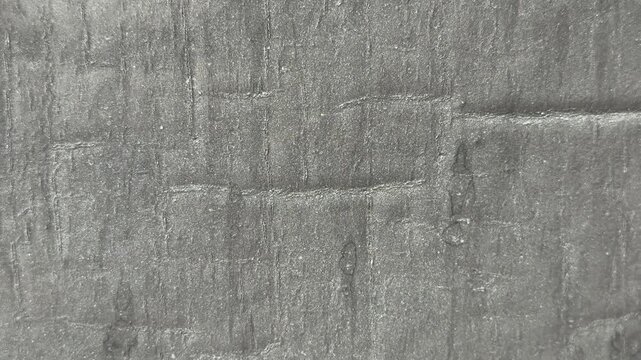 Close-up uniflex waterproofing membrane granular surface showing textured asphalt granules seams subtle weathering suggests