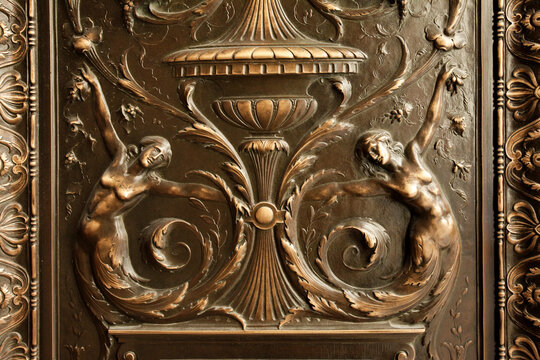 Ornate bronze architectural relief with classical figures