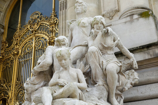 Classical sculpture group with gilded gate detail in Paris