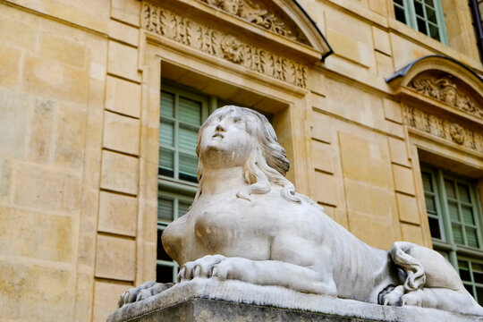 Classical stone female sphinx sculpture on historic Paris building facade