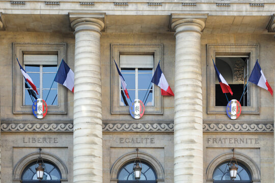 French flags on historic civic building facade