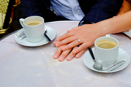 Coffee cups and hands at outdoor Paris caf&eacute; table
