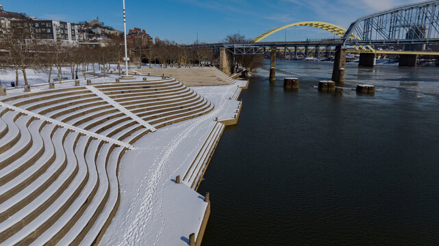 Aerial view of the snow-covered terraced steps of Smale Riverfront Park along the Ohio River with bridges in the background Cincinnati, Ohio, United States.