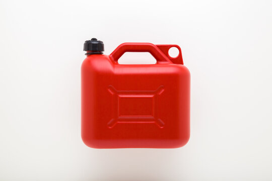 New red plastic 5L canister for car petrol on light gray table background. Closeup. Flat lay. Top down view.