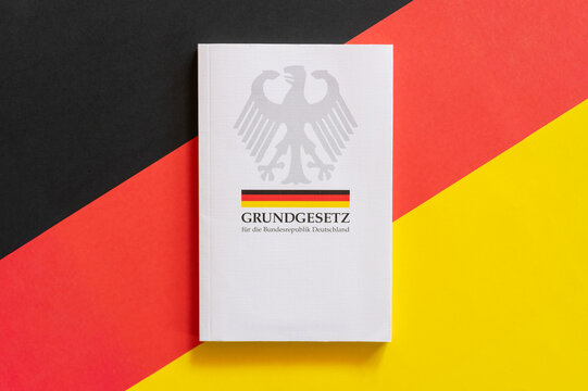 Grundgesetz der Bundesrepublik Deutschland auf deutscher Flagge als Symbol f&uuml;r Demokratie und Rechtsstaat