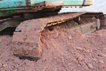 Fototapeta premium Excavator tracks in sand construction site equipment outdoor close-up machinery impact
